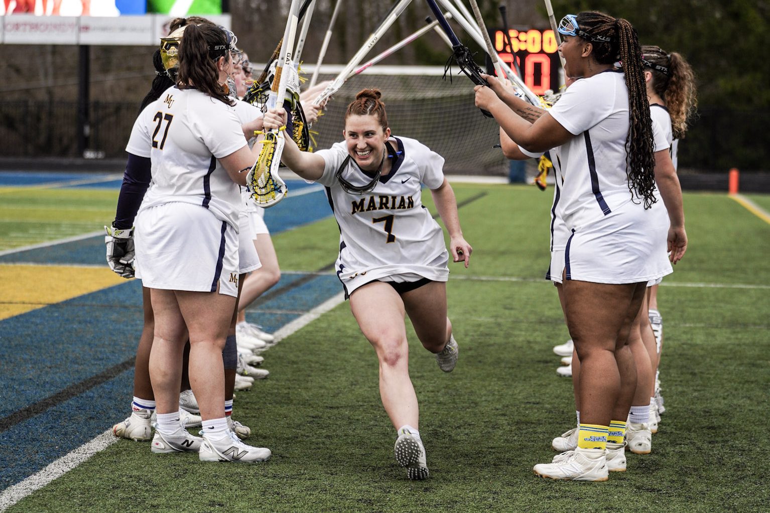 NAIA college lacrosse player celebrating running onto the field
